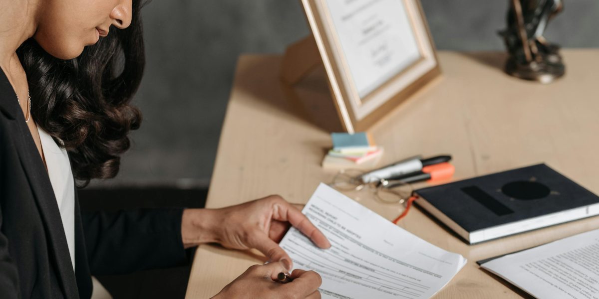 An individual receiving guidance from an expert while reviewing important legal documents, ensuring clarity and compliance.