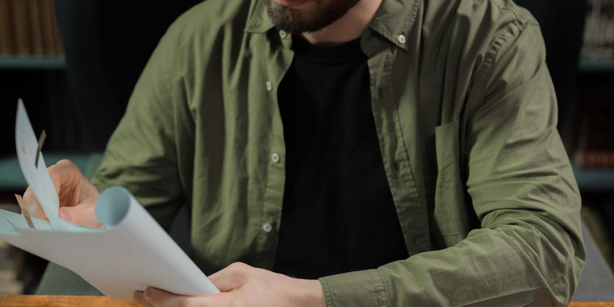 A person looks thoughtfully at complex data or documents, reflecting the overwhelming nature of a fast-moving market.