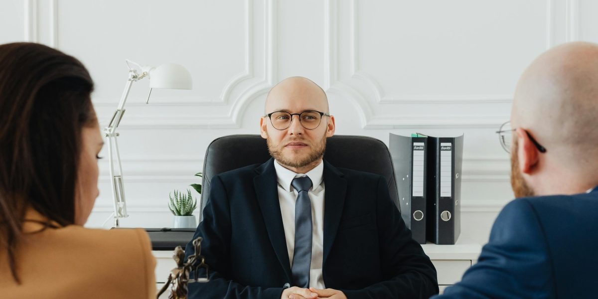 A person receiving professional advice from a legal expert in a formal office setting.
