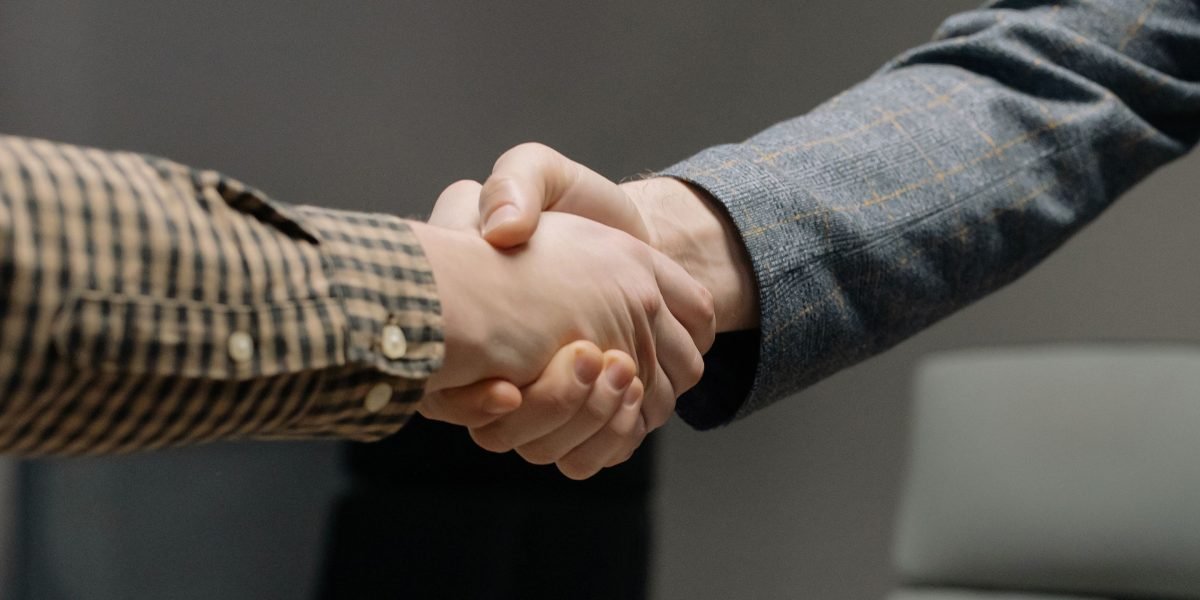 Professionals shaking hands, symbolizing the successful completion of a real estate transaction and the finalization of a property purchase.