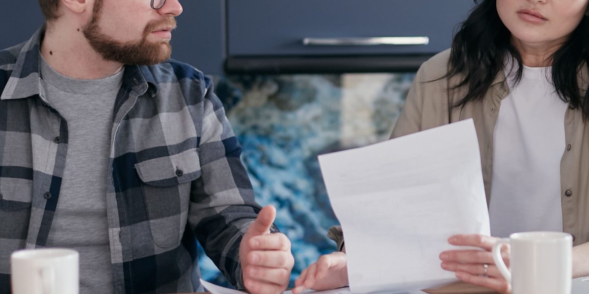 A couple discussing finances, reflecting the importance of setting clear goals and budget.