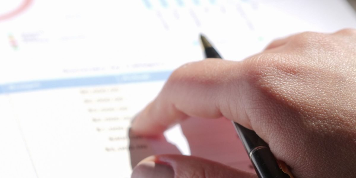 A professional analyzing financial data and reports to understand market trends and forecasts.