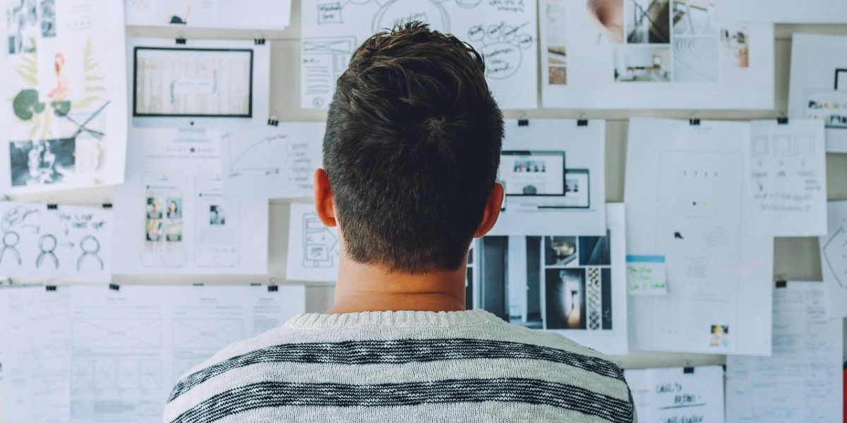 A person focused on a whiteboard, strategizing future investment plans.