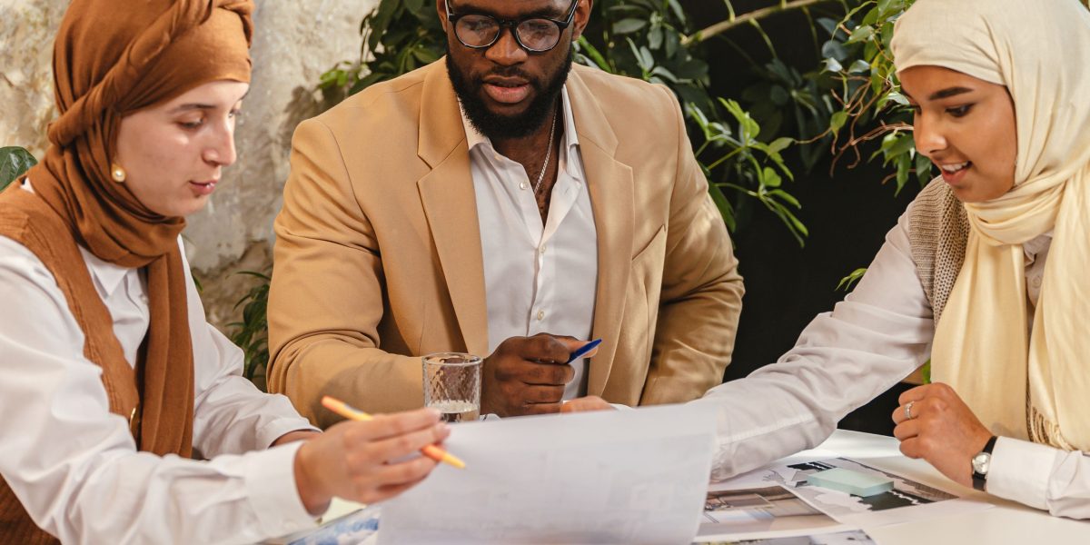 A business team collaborates on a blueprint, representing strategic discussions for commercial land development in a growing city.