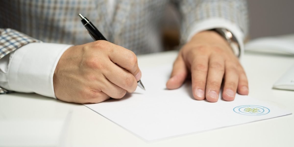 The pivotal moment of signing a contract, representing the legal step in property acquisition.