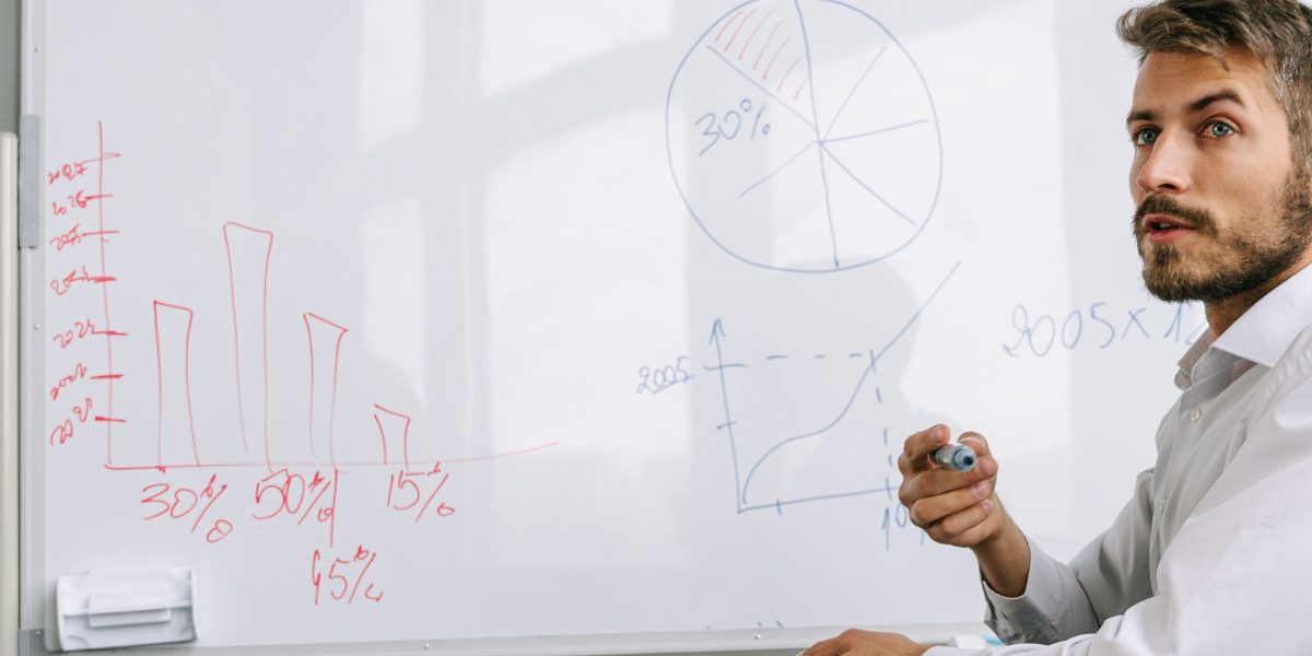 A person using a whiteboard to strategize and identify promising neighborhoods for property investment.